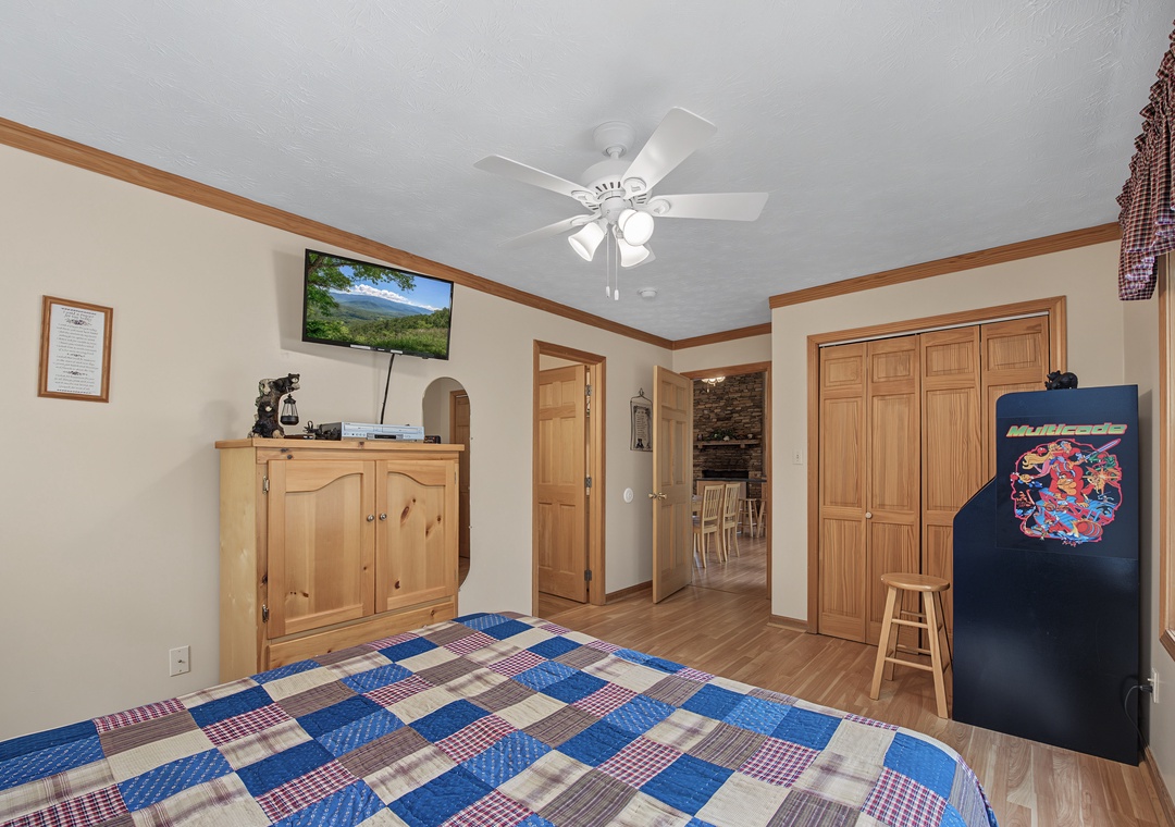 Relax in your cozy bedroom with warm wood tones, a ceiling fan for comfort, and a TV to unwind. Natural light and charming mountain views make this your peaceful retreat.