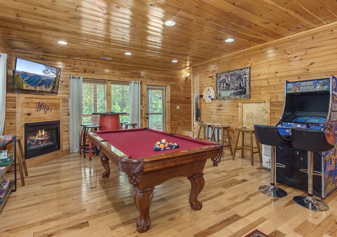 Your game room awaits with pool table, arcade games, and cozy fireplace for memorable evenings.