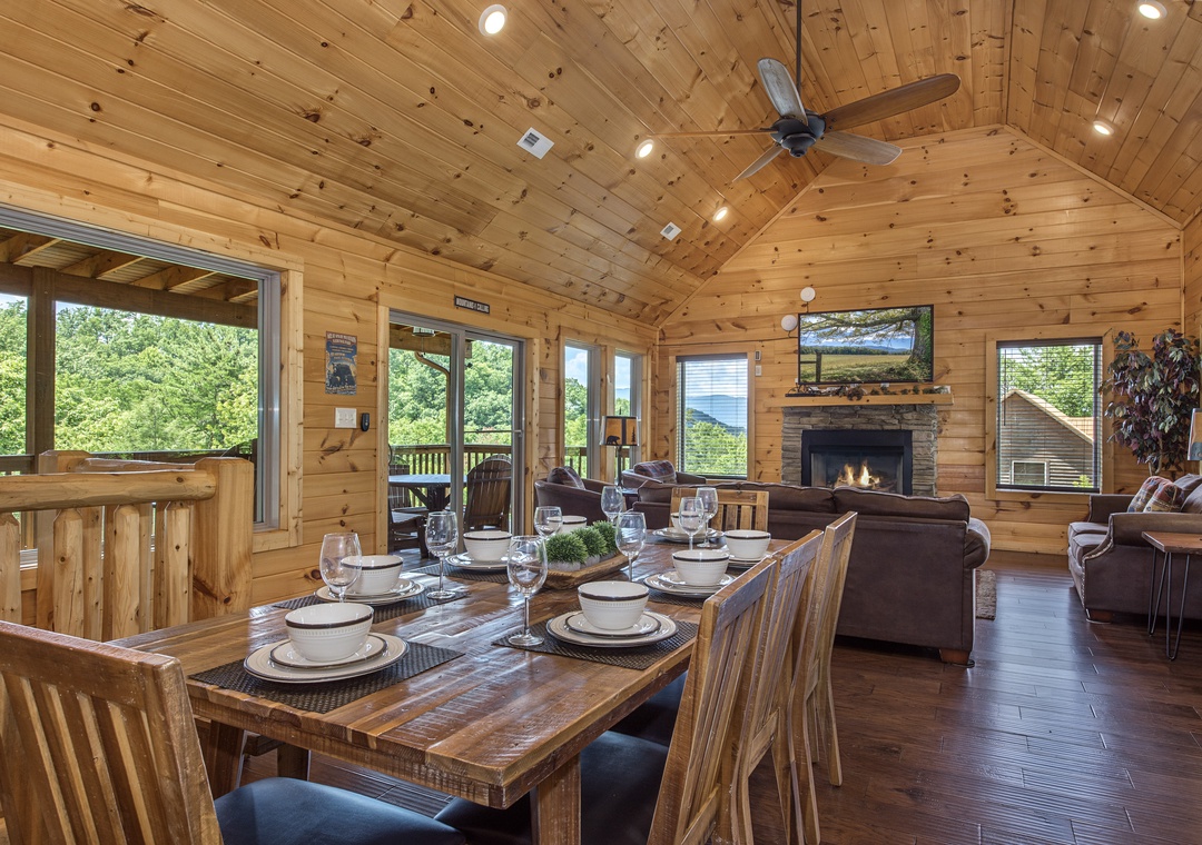 Gather around the dining table and soak in mountain views through floor-to-ceiling windows. Warm wood walls, a cozy fireplace, and an open layout create the perfect space for your group to relax together.