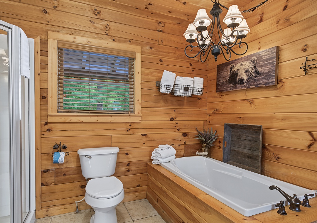 Unwind in your rustic cabin bathroom, where a deep soaking tub with plush towels awaits after a day of adventure. Warm wood tones create a cozy mountain retreat.
