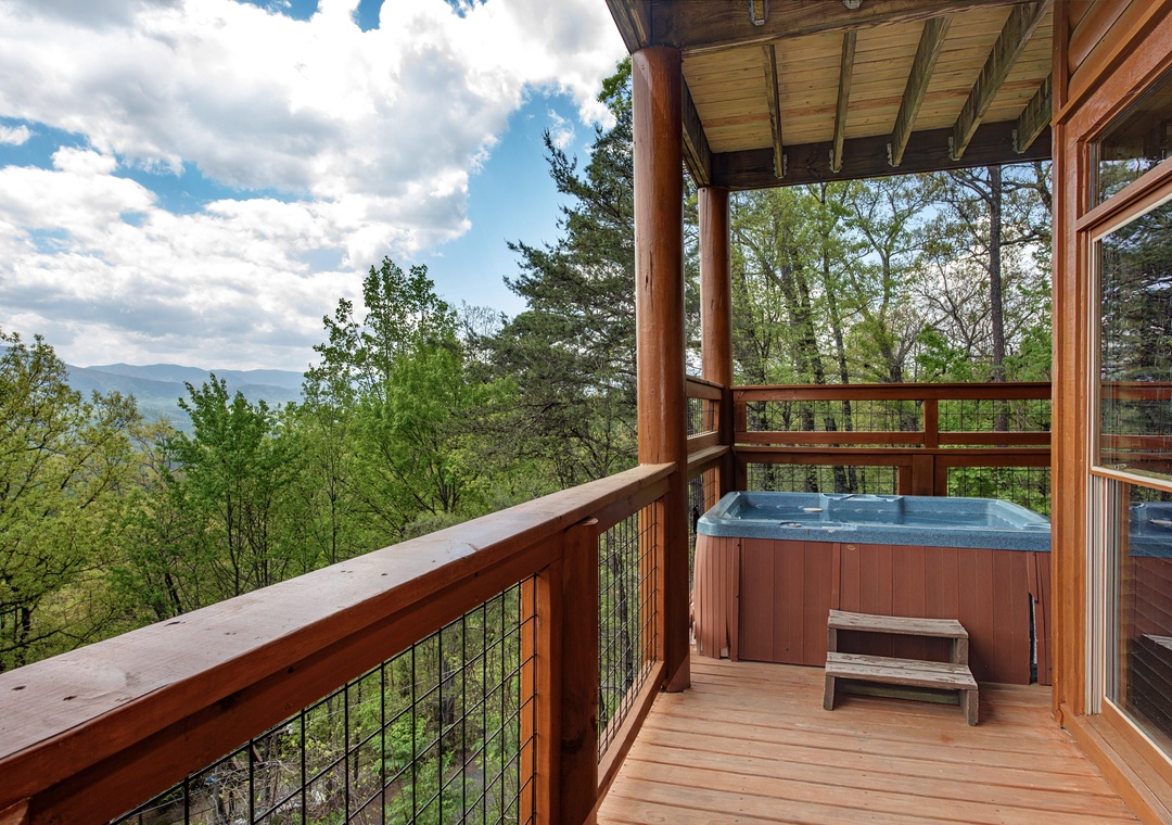 Soak in your private hot tub while surrounded by breathtaking mountain views and lush forest canopy from this elevated deck.