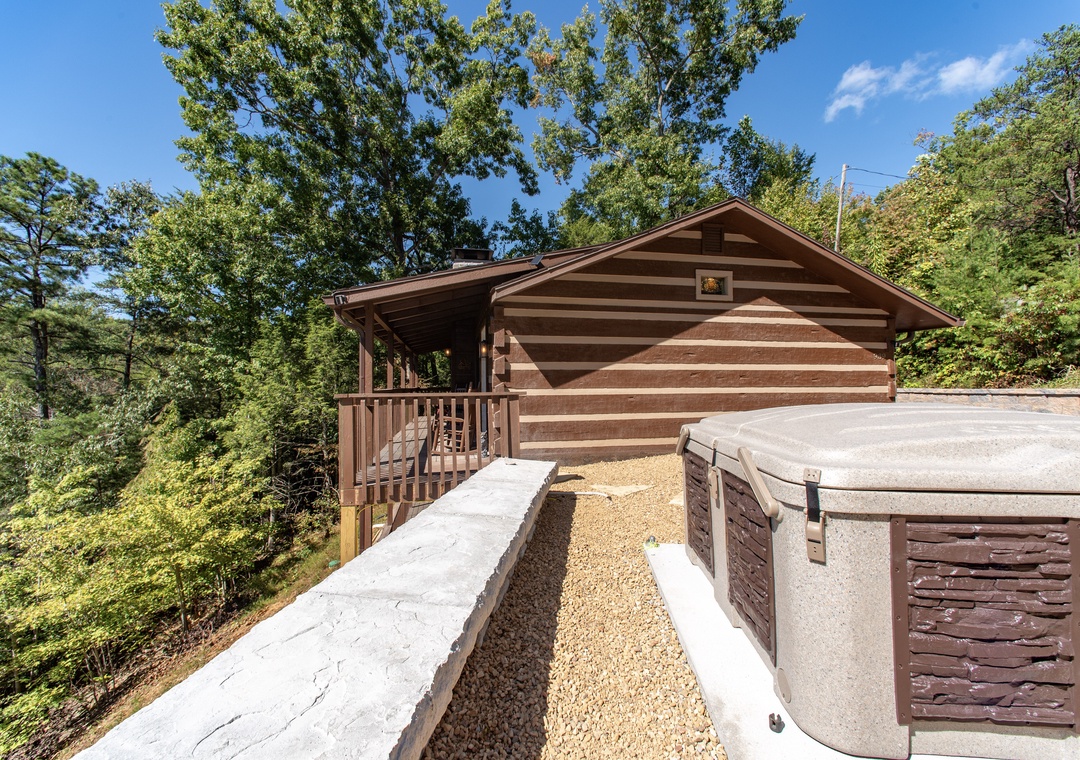 This charming log cabin nestled among towering trees offers a serene mountain escape. Your private retreat features rustic wood construction, a welcoming covered porch, and convenient parking—all surrounded by lush forest scenery.
