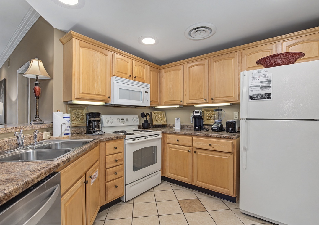 Your fully equipped kitchen awaits with granite counters, warm wood cabinets, and everything needed for home-cooked meals during your stay.