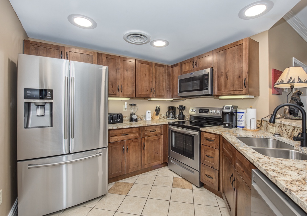 Your fully equipped kitchen features granite countertops, stainless steel appliances, and warm wood cabinets—everything you need to create memorable meals during your stay.