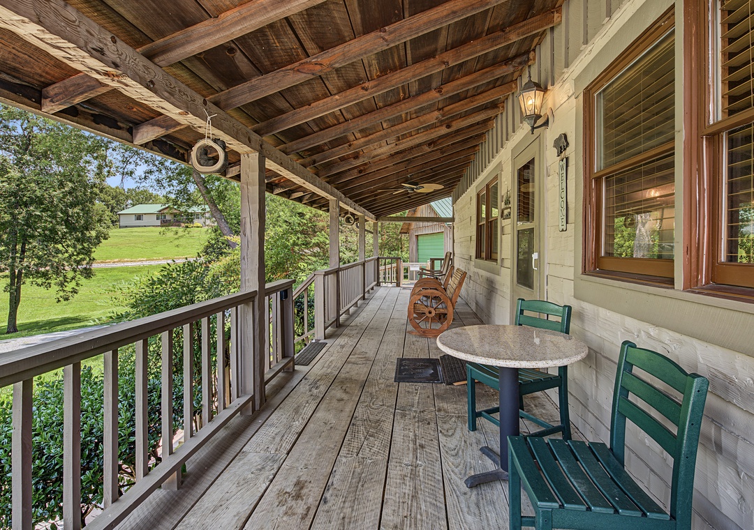 Picture yourself savoring morning coffee on this charming covered porch, where rustic wood beams frame peaceful countryside views. Relax in the rocking chairs and let the fresh air surround you.