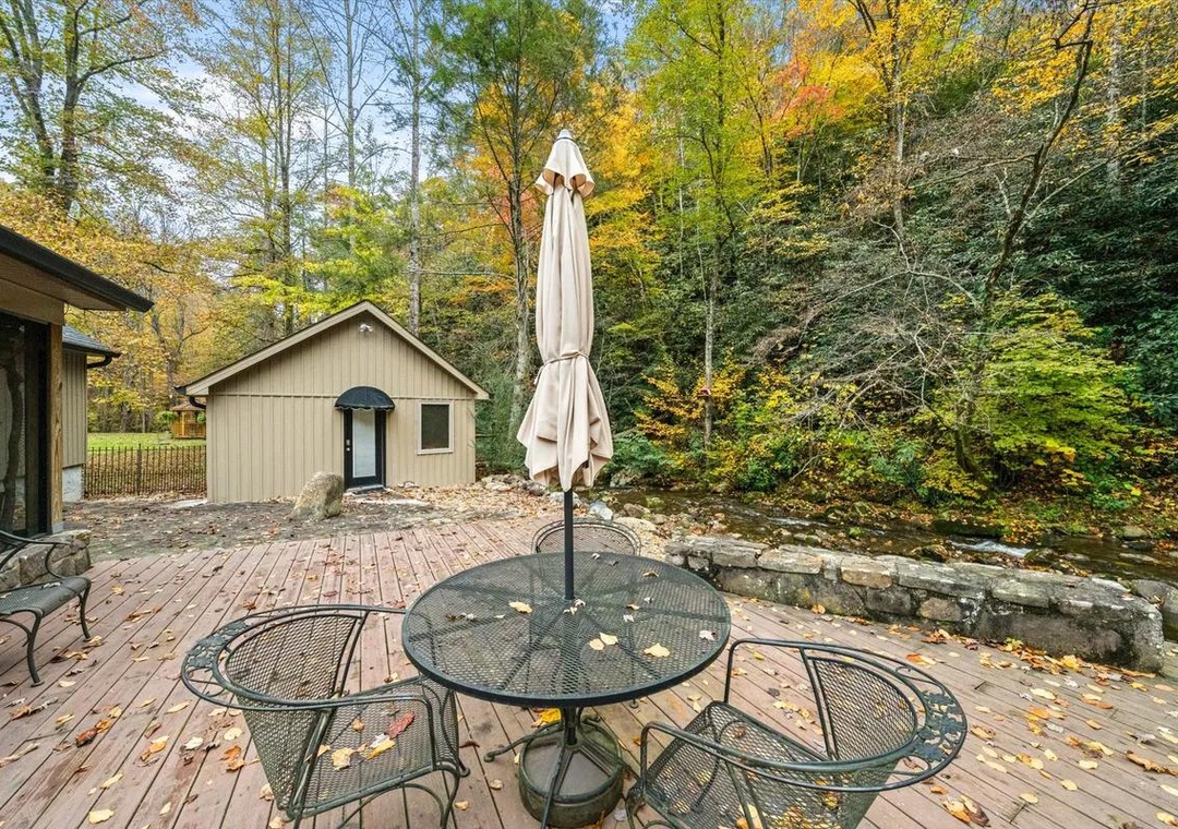 A private outdoor deck nestled among vibrant autumn foliage creates your perfect retreat for morning coffee or evening relaxation in nature.