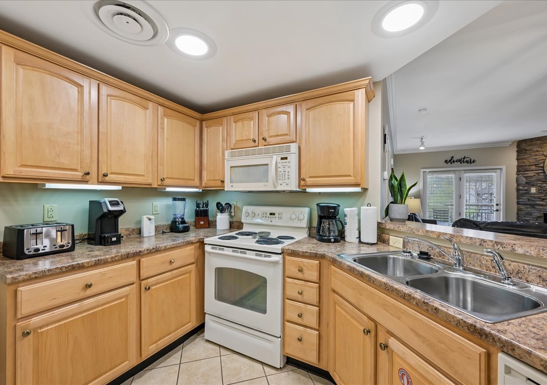 Your fully equipped kitchen awaits with granite counters, warm wood cabinets, and everything needed to create memorable meals during your stay.