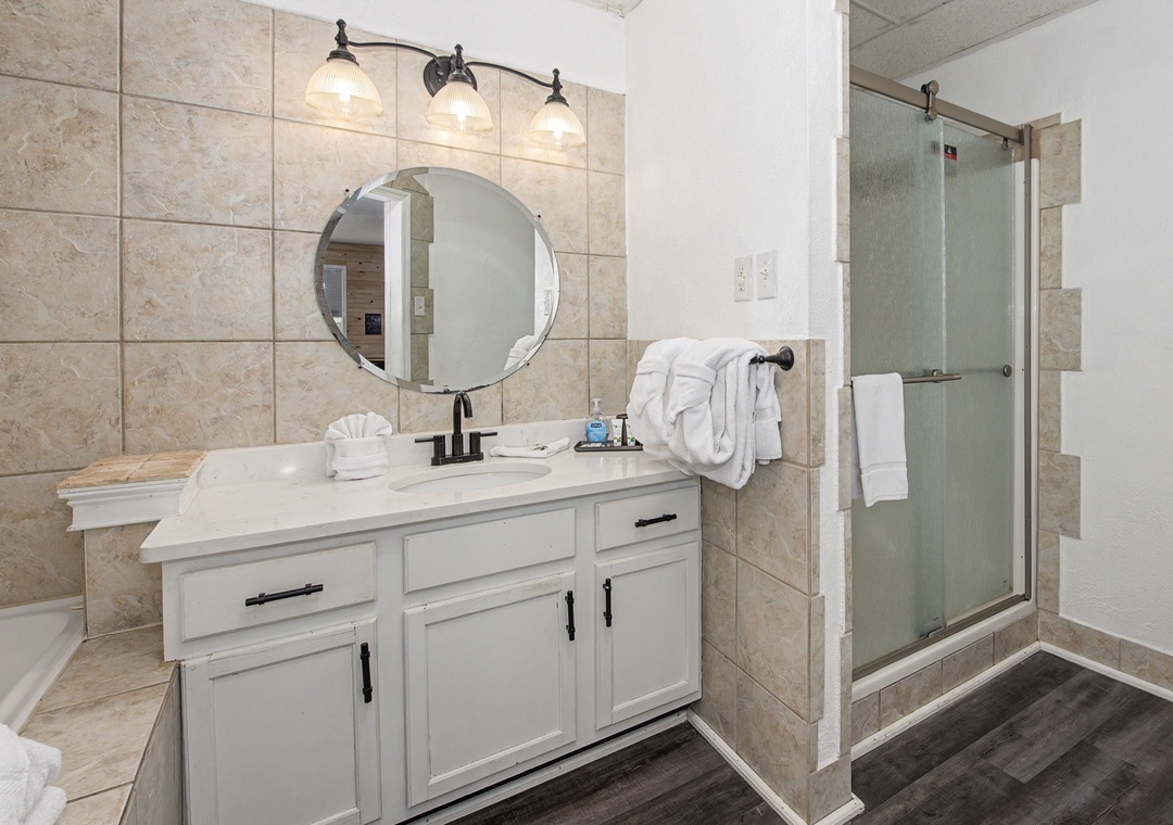 Your private spa-like bathroom features elegant tile, premium fixtures, and fluffy towels ready for your relaxing retreat.