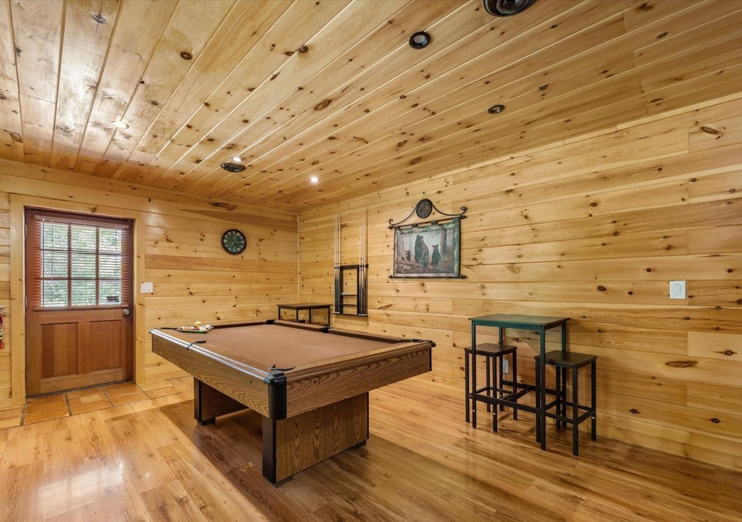 Challenge friends to pool in your rustic game room with wood-paneled walls and cozy cabin charm.