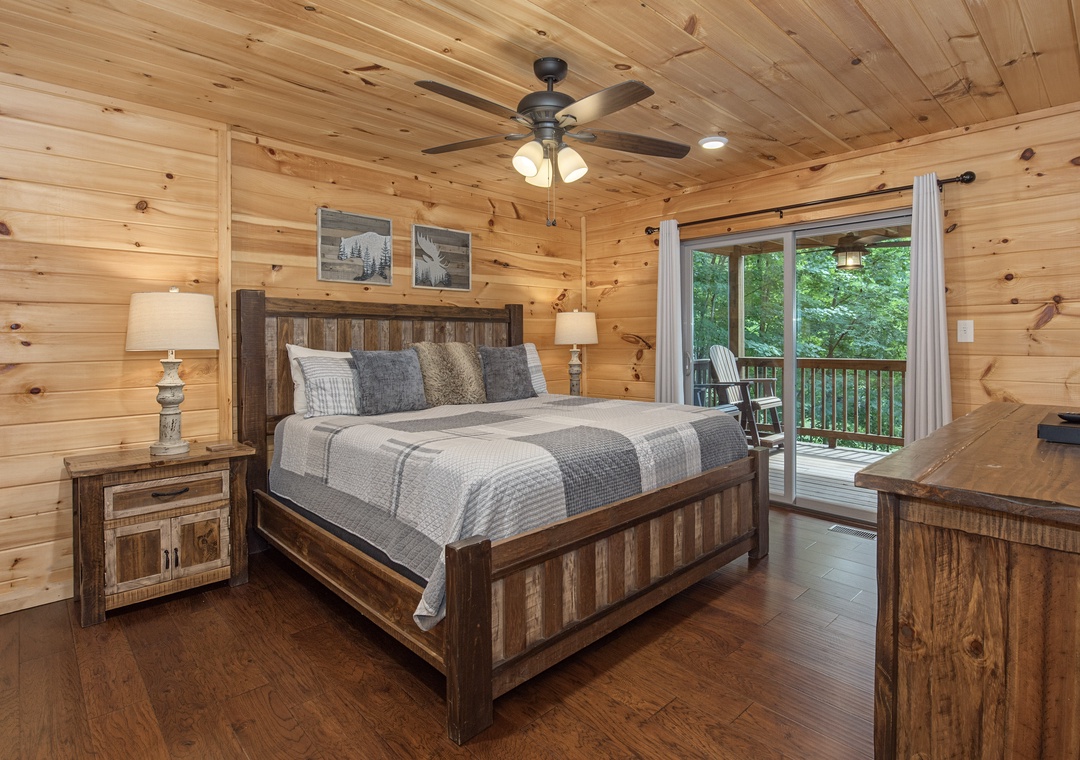 Step into your cozy retreat, where warm wood surrounds you and natural light streams through sliding doors to your private balcony. Unwind beneath the gentle ceiling fan and wake to peaceful forest views just beyond your doorstep.