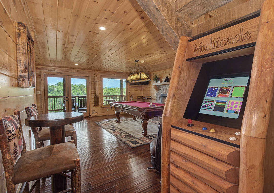 Challenge your group to a pool game or classic arcade fun in your private game room, complete with forest views through wide balcony doors—perfect for friendly competition and making vacation memories together.