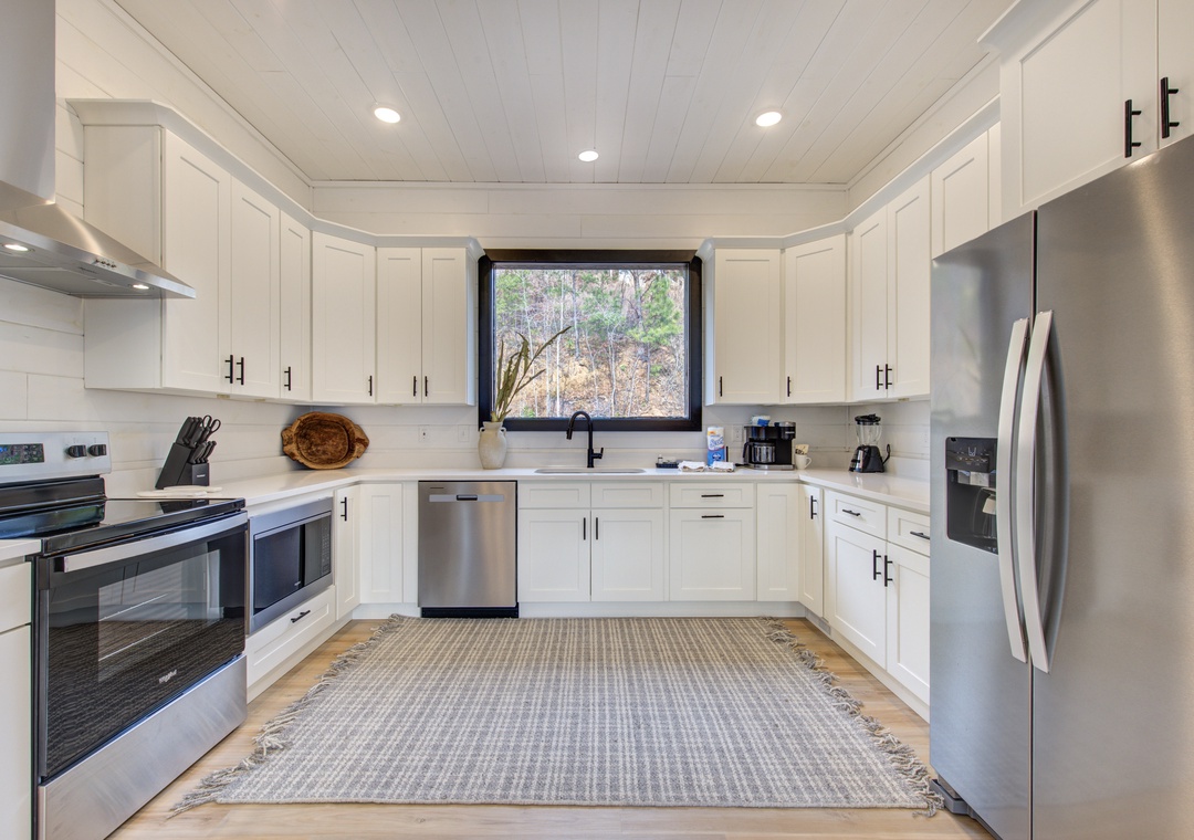This bright, fully-equipped kitchen invites you to cook with friends. Stainless appliances, ample counter space, and a garden window create the perfect culinary retreat.