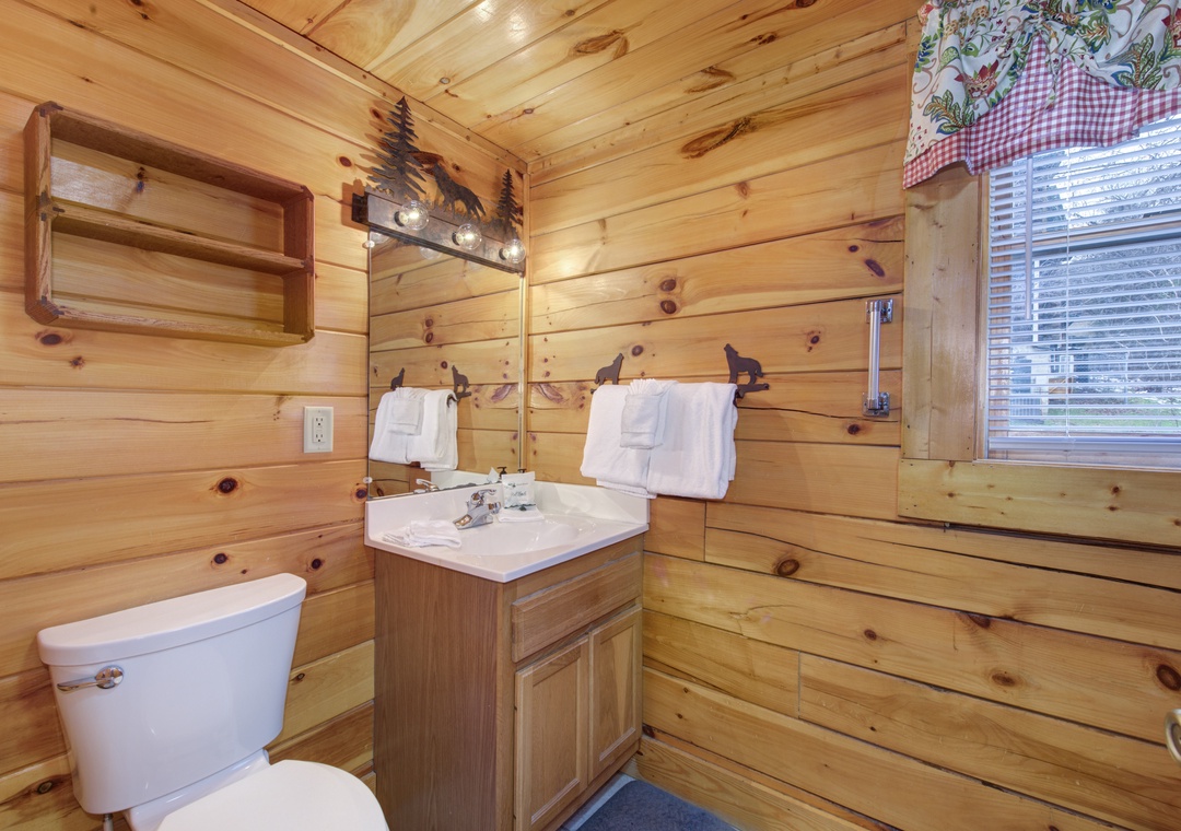 Step into your cozy log cabin bathroom, where warm wood walls and rustic wildlife touches create the perfect mountain retreat atmosphere.