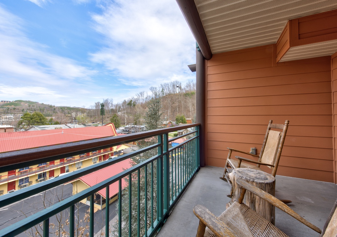 Step onto your private balcony with rustic wooden chairs and soak in the mountain town views stretching across rolling hills.