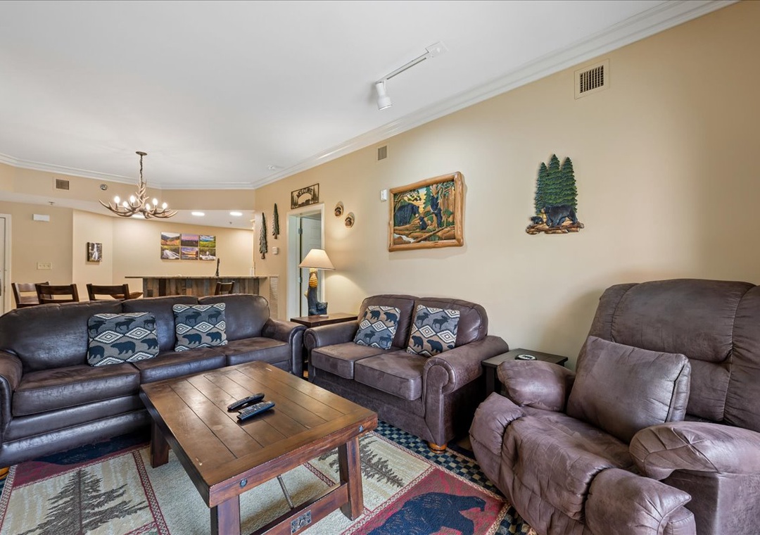 Sink into plush leather seating and rustic charm in this cozy living room, where mountain artwork and warm lighting create your perfect retreat.