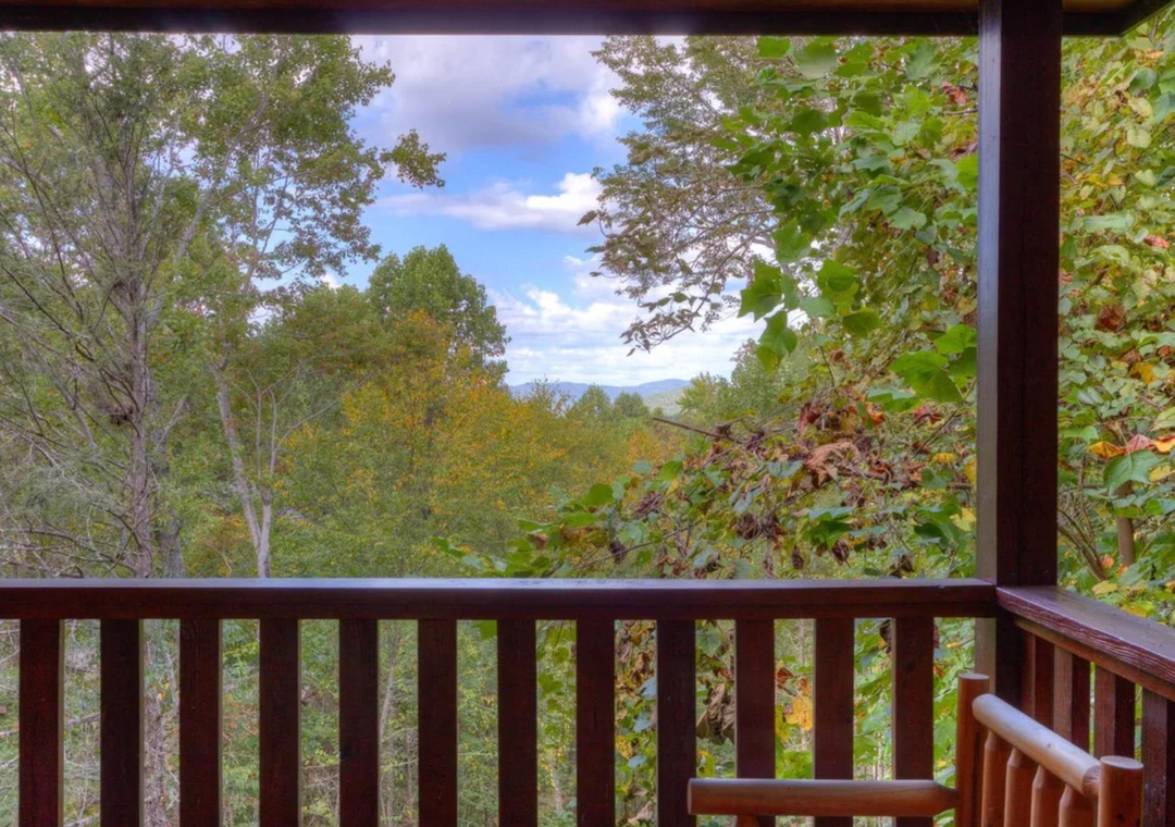 Breathe in the fresh mountain air from your private balcony, where autumn foliage frames peaceful views of the valley and distant peaks beyond.