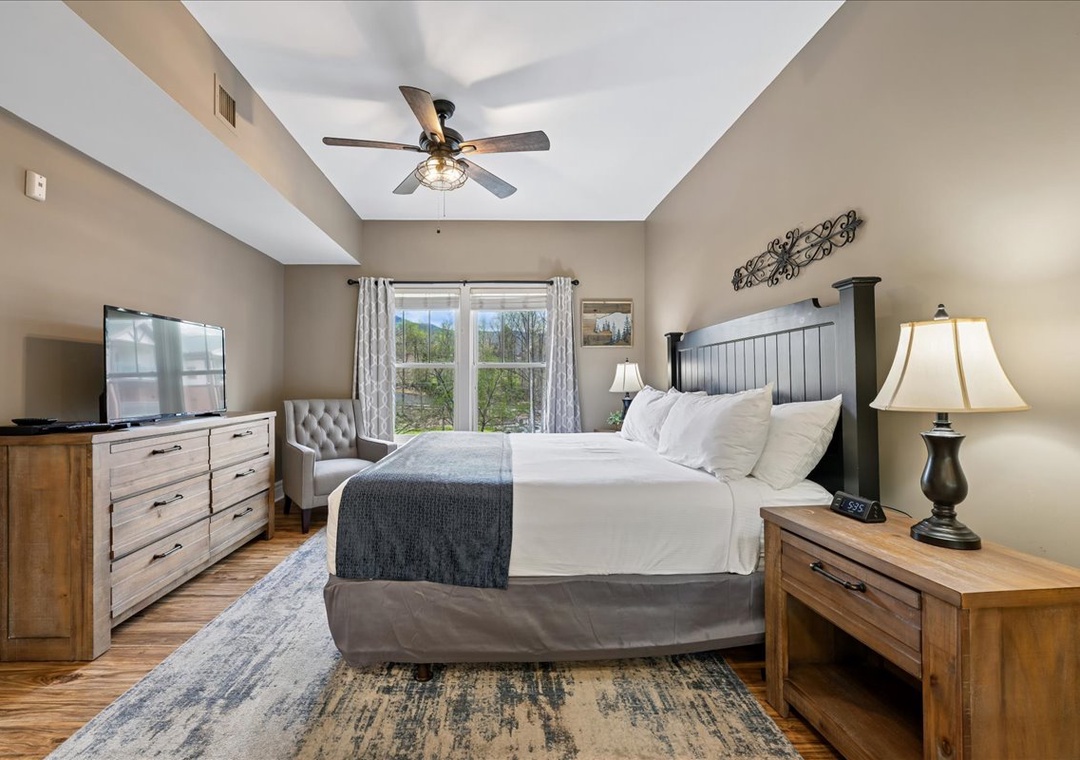 Sink into your plush king bed beneath soothing ceiling fan breezes. Warm wood tones and mountain views create your perfect retreat.