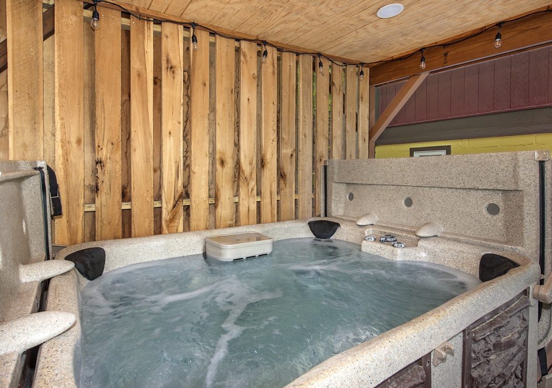 Slip into the hot tub's warm, bubbling water and feel your stress melt away under the cozy wood-paneled ceiling.