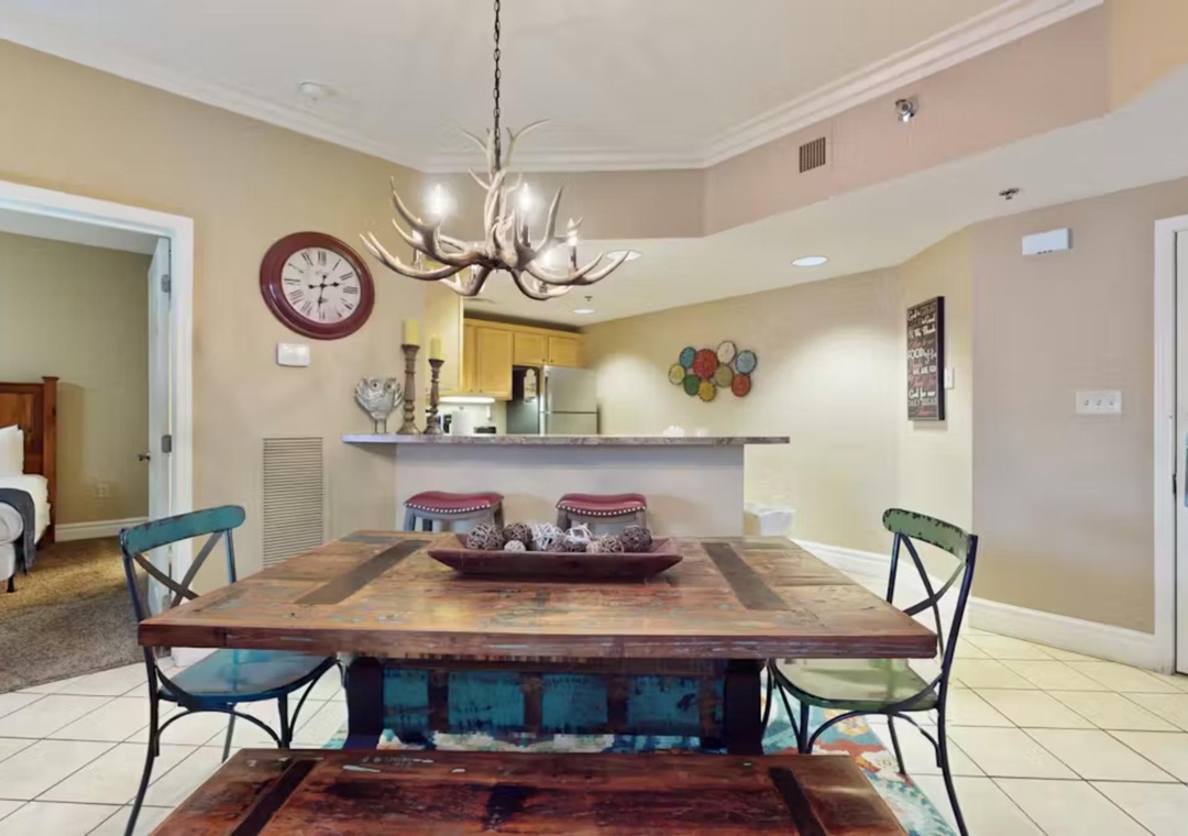 Gather around your rustic dining table beneath the antler chandelier for memorable meals together in this open-concept space.