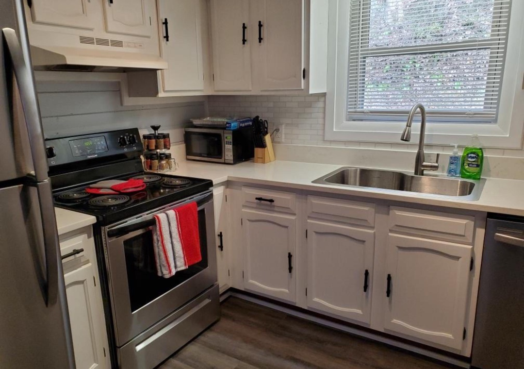 You'll love preparing meals in this bright, fully-equipped kitchen with stainless steel appliances, white cabinetry, and everything you need for a comfortable stay.