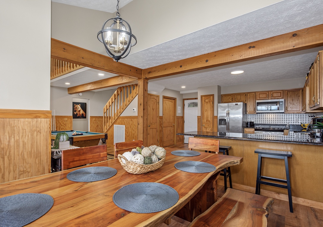 Gather around your spacious dining table, where the warmth of rich wood and vaulted ceilings creates an inviting atmosphere for shared meals and memories. Your fully-equipped kitchen stands ready for culinary adventures.