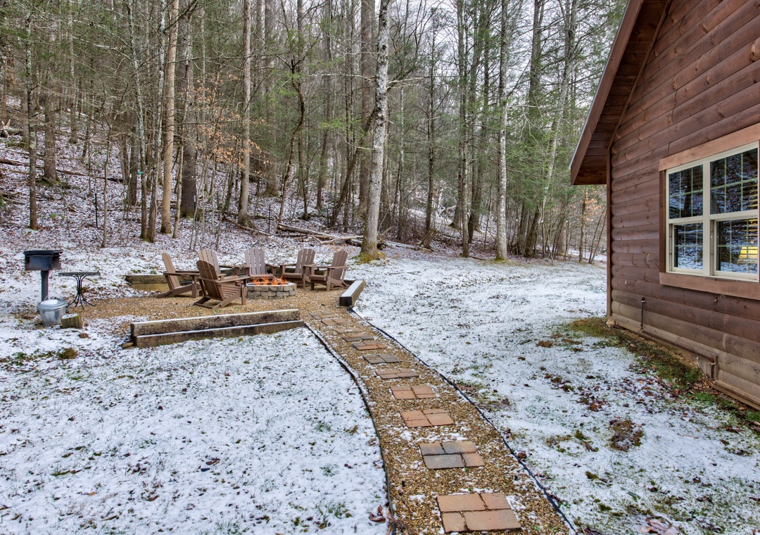 A rustic log cabin nestled among snow-dusted trees, featuring a welcoming stone pathway and outdoor seating area perfect for peaceful winter retreats.