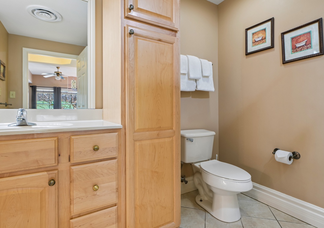 Step into your private bathroom featuring warm wood cabinetry, plenty of storage, and fresh towels waiting for you.
