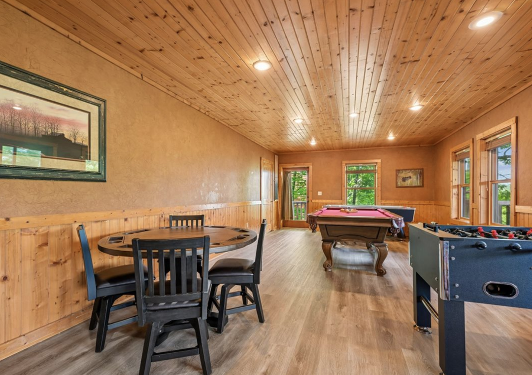 Your private game room invites friendly competition with billiards and foosball under warm wood ceilings, plus a cozy dining nook for snacks and laughs between games.