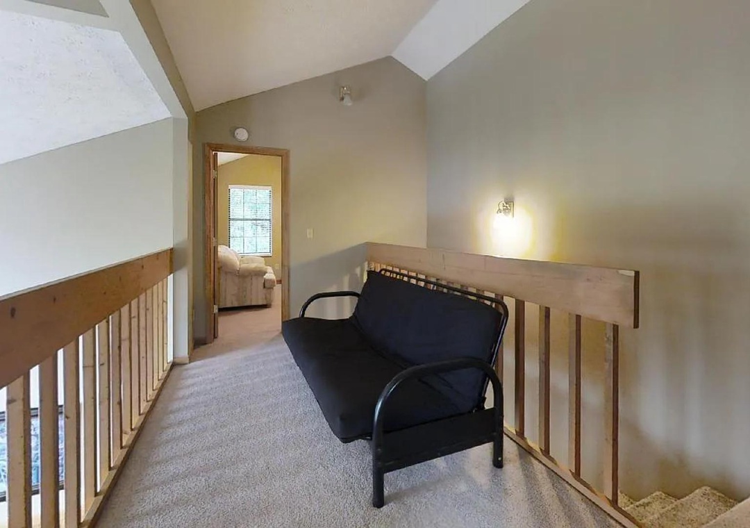 An upstairs landing connects bedrooms with soft lighting and vaulted ceilings—your quiet transition space between restful moments.