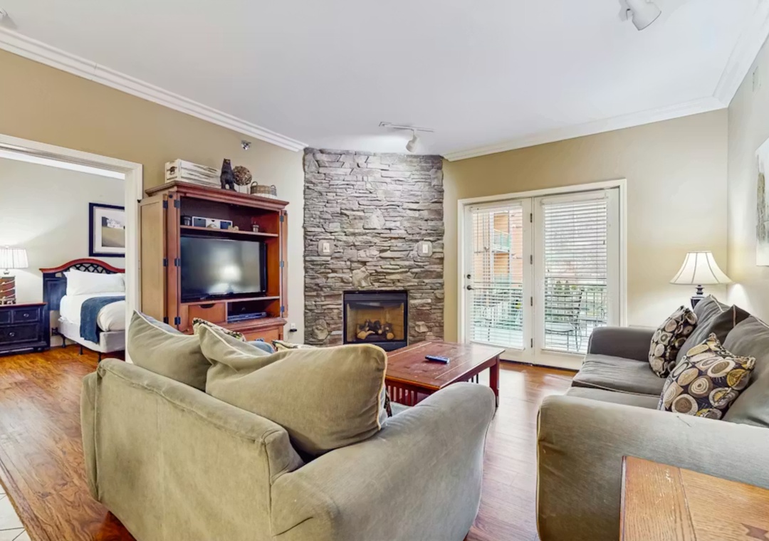 Sink into plush sofas by your stone fireplace, with entertainment center and bedroom nearby for ultimate relaxation.