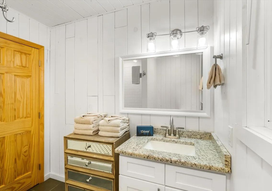 Crisp white shiplap walls frame your bright, inviting bathroom, where plush towels await and thoughtful details make every morning feel special.