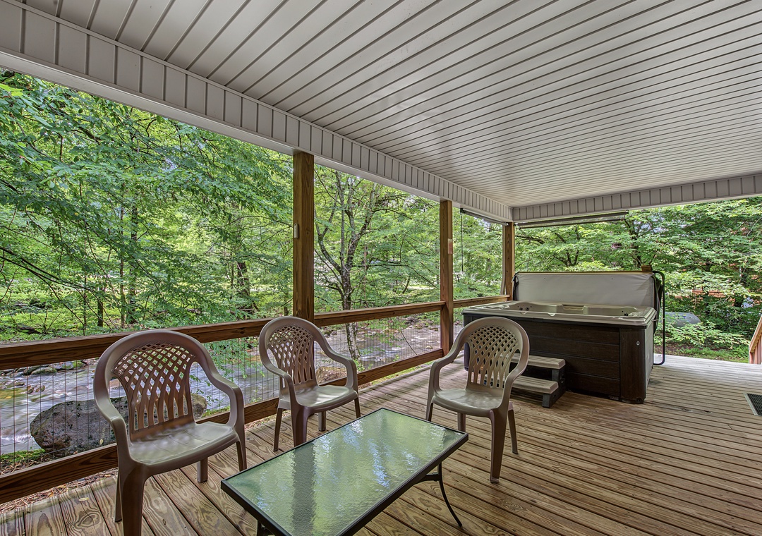 Unwind on your private covered deck overlooking lush forest greenery, complete with comfortable seating and a relaxing hot tub perfect for soaking away stress.