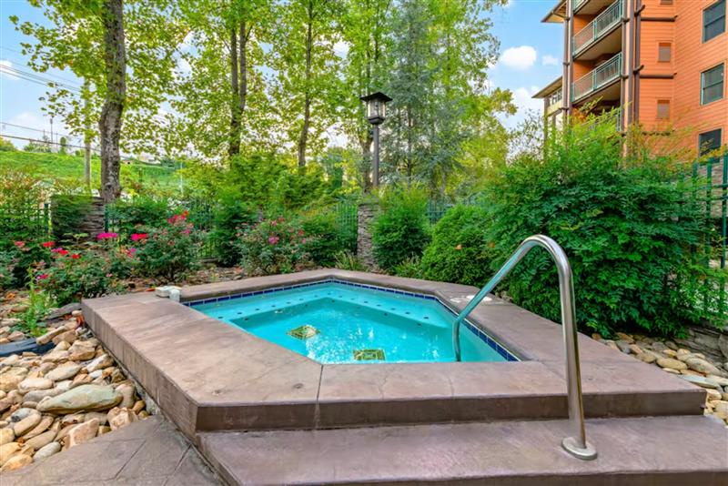 Soak in the bubbling hot tub surrounded by lush gardens and mature trees for ultimate relaxation.
