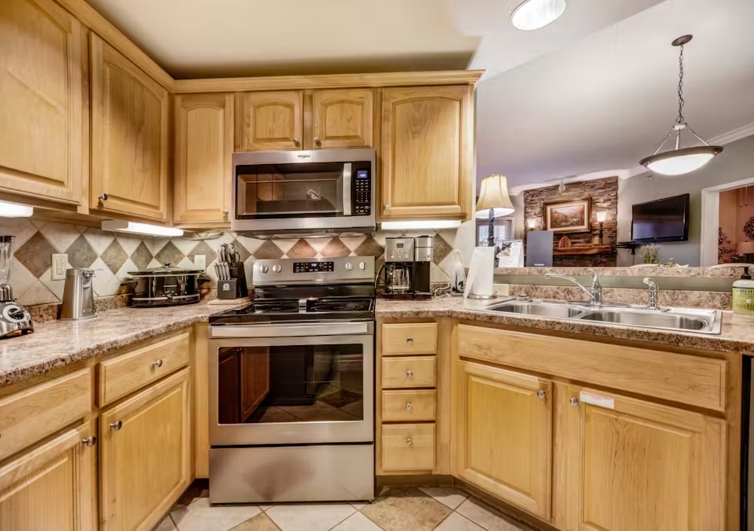 Your fully-equipped kitchen features warm wood cabinets, granite counters, and stainless appliances for memorable home-cooked meals.