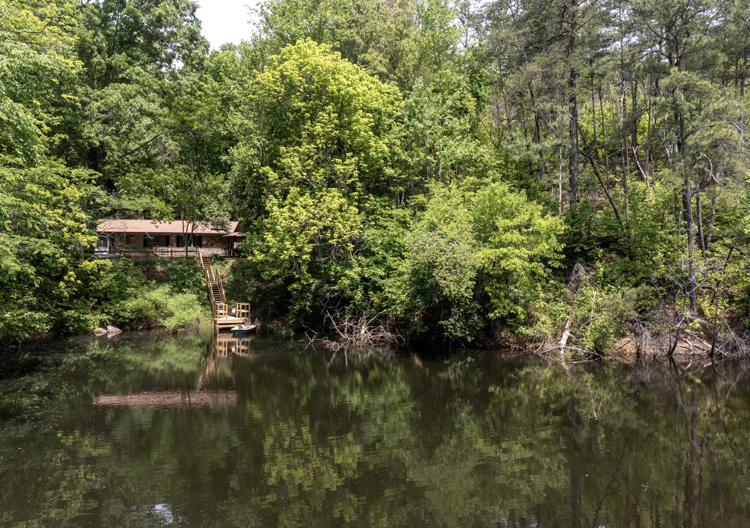 Nestled among lush woodland along a tranquil waterfront, this charming cabin offers a private deck, fishing access, and serene natural surroundings perfect for a peaceful retreat.
