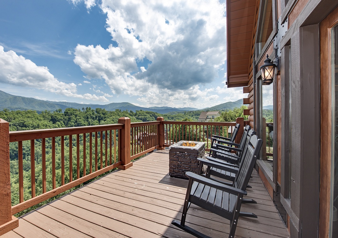 Relax in your rocking chair and watch clouds drift over forested mountain ridges. The deck's stone fire pit adds warmth to cool evenings under open skies.