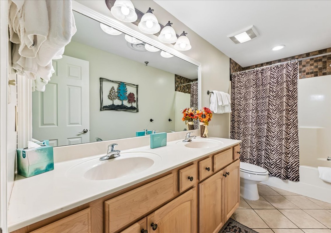Refresh in your spacious bathroom with dual sinks, stylish tile work, and modern lighting creating the perfect morning routine space.