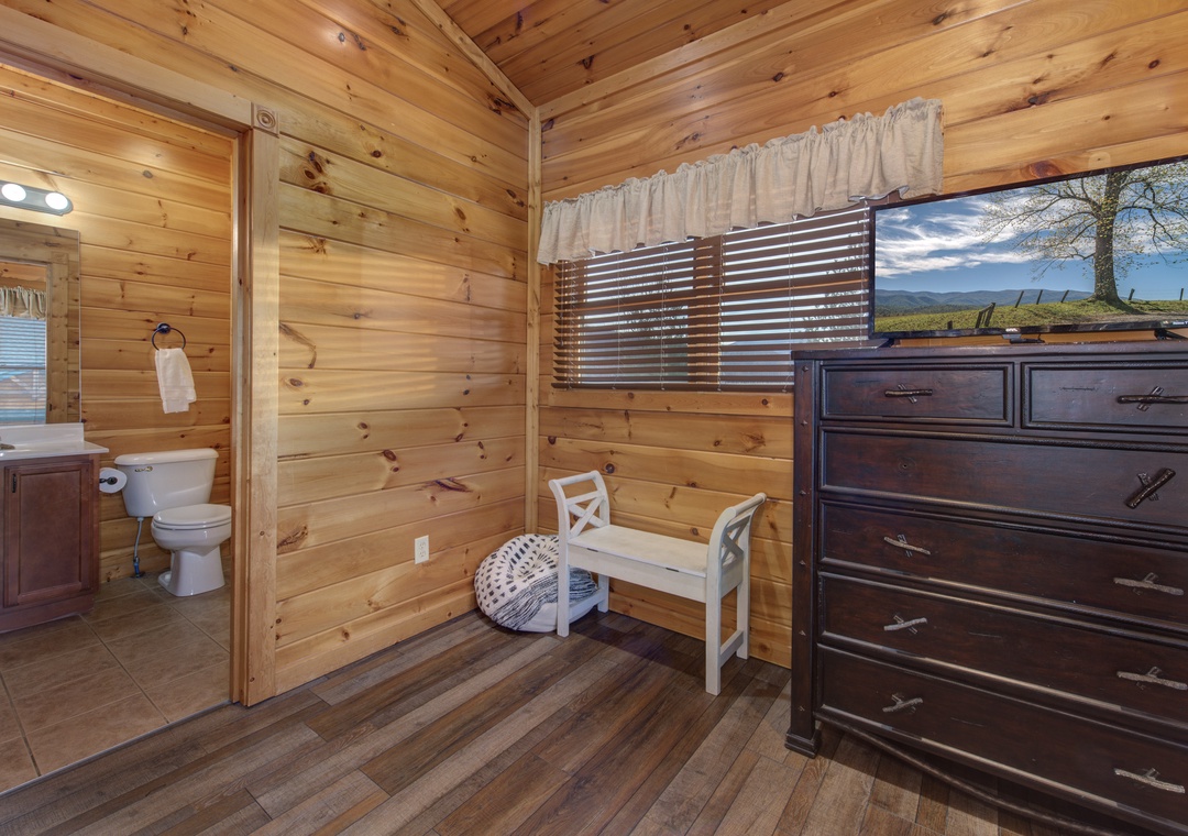 Warm knotty pine walls surround your cozy space, where natural light filters through the window and your private bathroom awaits just steps away.