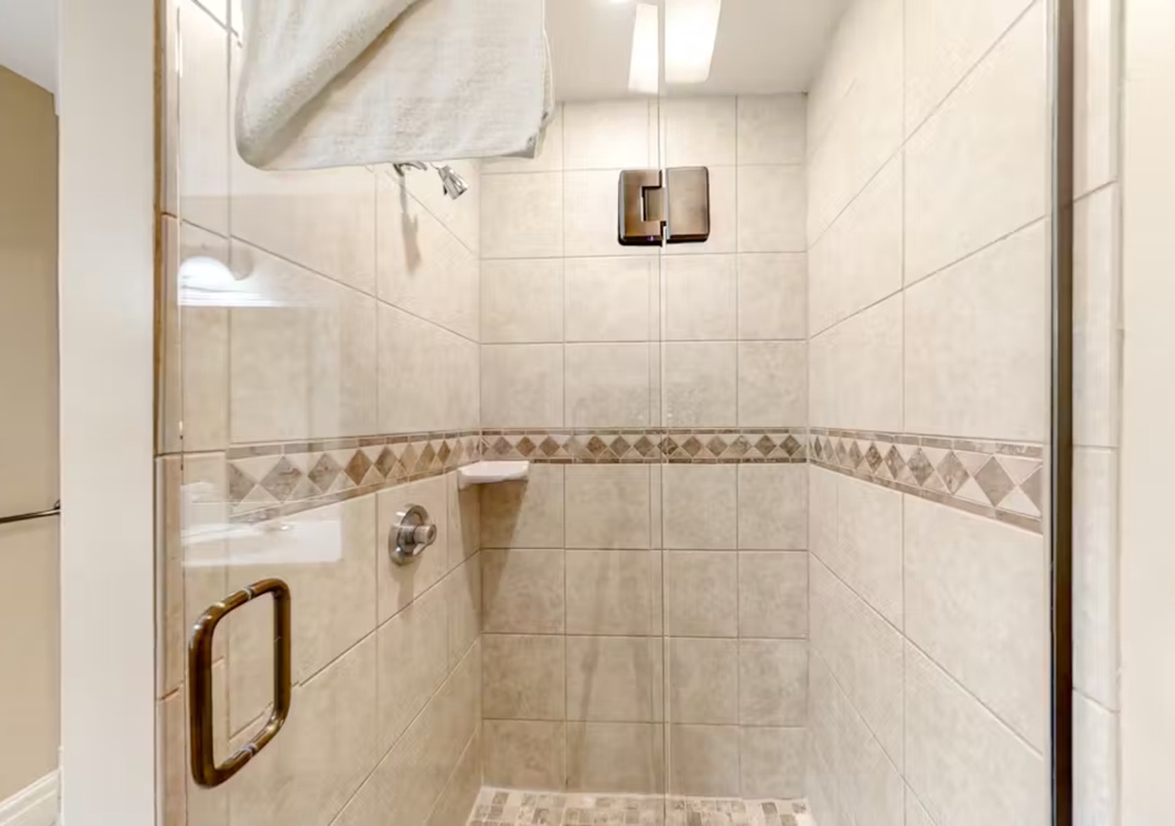 Step into your elegant tiled shower with decorative accents and modern fixtures for a refreshing start to your day.
