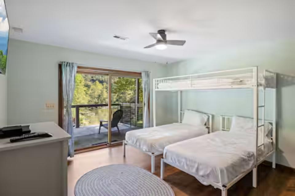 Rest comfortably in this bright bedroom featuring bunk beds and your own private balcony overlooking lush greenery.