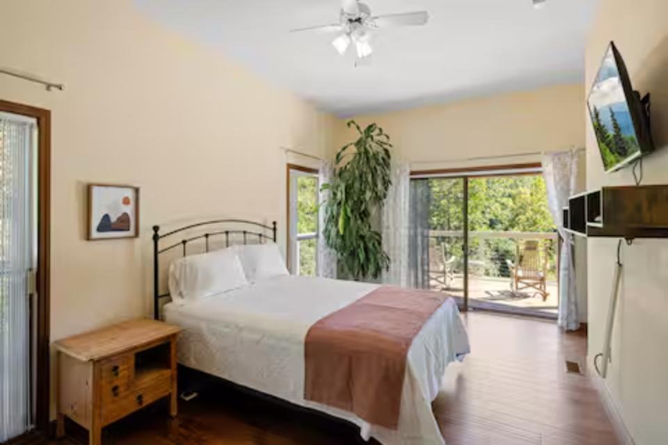 Your bright bedroom features crisp white linens, garden views through sliding doors, and modern amenities for a restful stay.