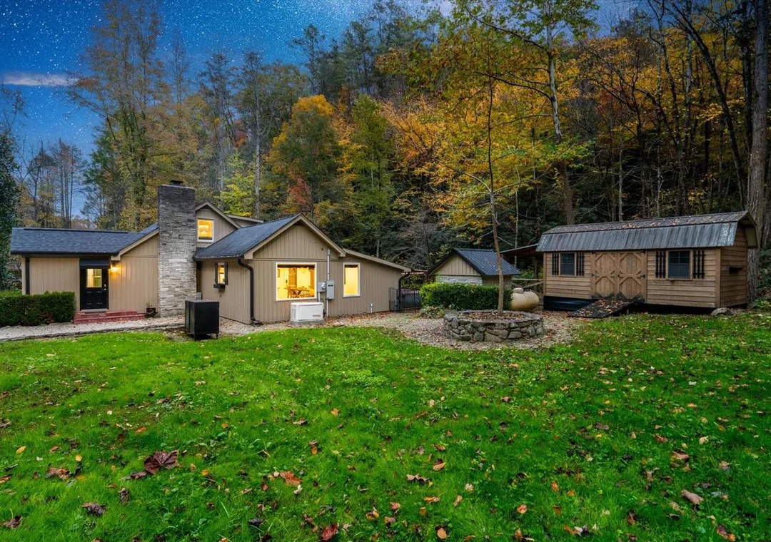 Secluded retreat nestled in vibrant autumn woods with separate guest cabin and spacious lawn for outdoor gatherings.