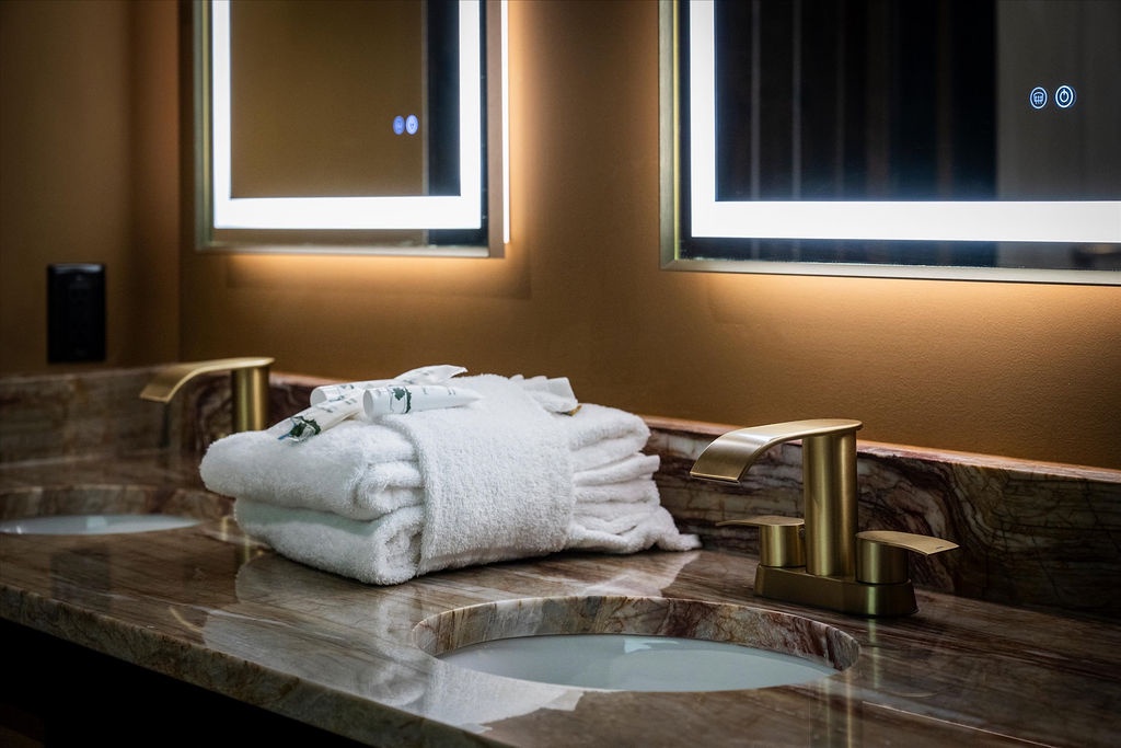 Sink into luxury with plush towels, elegant gold fixtures, and soft ambient lighting that transforms your daily routine into pure relaxation.