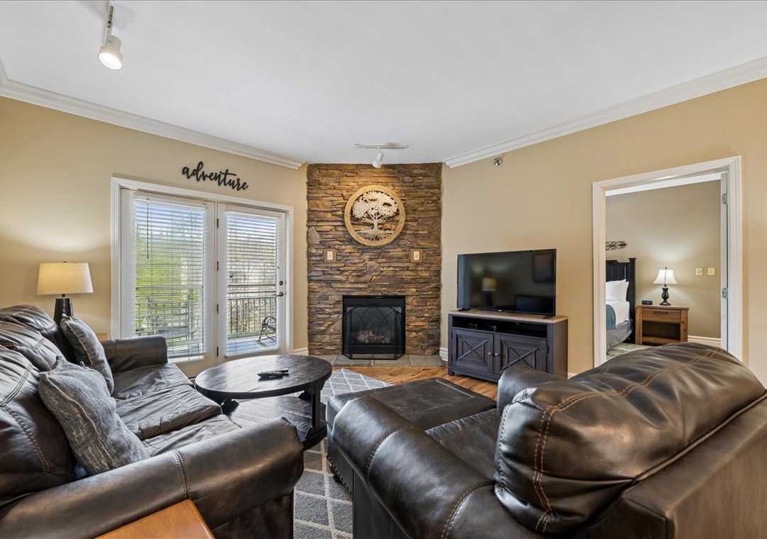 Cozy up in your spacious living room, where leather seating and a stone fireplace create the perfect atmosphere for relaxation.