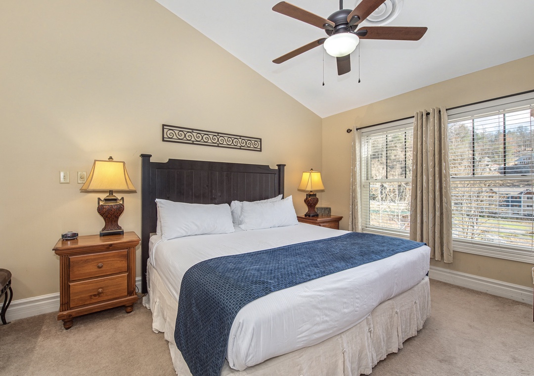 Sink into crisp white linens and cozy blue accents in your peaceful bedroom retreat, with gentle ceiling fan breezes and warm natural light.