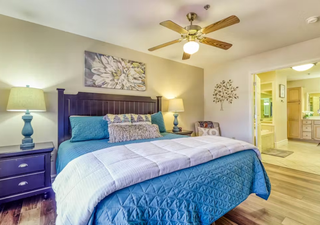 Unwind in your serene bedroom featuring calming blue bedding, elegant decor, and an ensuite bathroom for your comfort.