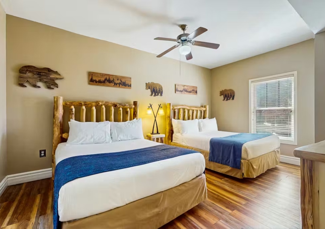 Sleep comfortably in this rustic-themed bedroom with twin log beds, crisp linens, and charming bear artwork creating your perfect mountain retreat.