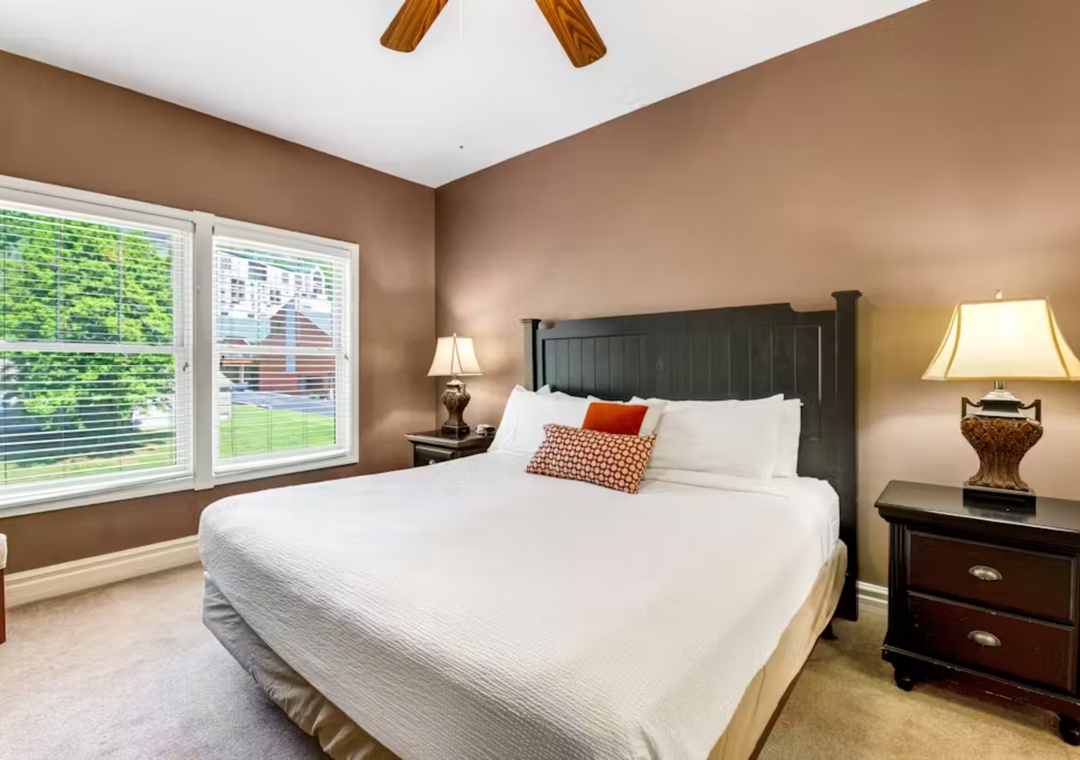 Sink into plush bedding and enjoy warm lighting in your peaceful bedroom retreat with garden views.