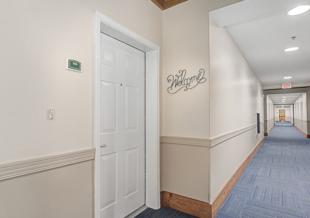 A welcoming hallway leads to your room, with cheerful 'Welcome' signage greeting you upon arrival.