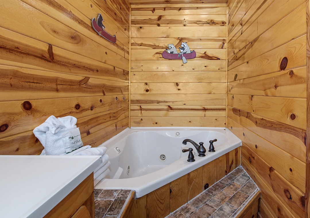 Slip into your private jetted tub, surrounded by warm pine walls and playful decor, perfect for unwinding after a day of mountain adventures.
